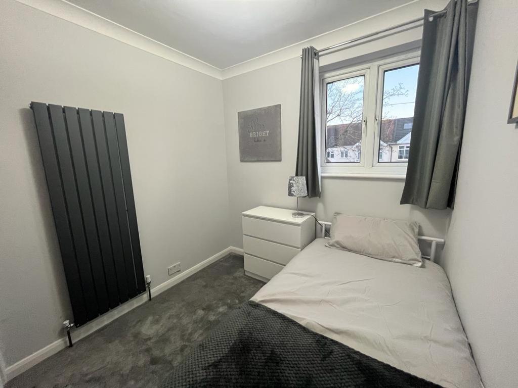 a small bedroom with a bed and a window at Gants hill in Barkingside