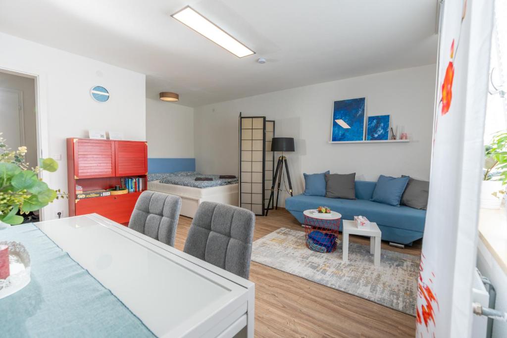 a living room with a blue couch and a table at #4 modern & comfortable apartment in Memmingen