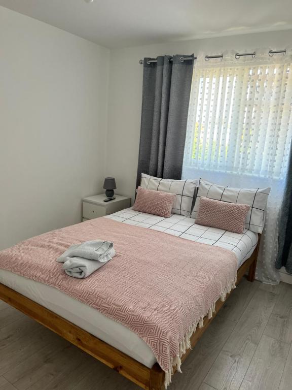 - une chambre avec un grand lit et une couverture rose dans l'établissement Sleep In oxford, à Oxford