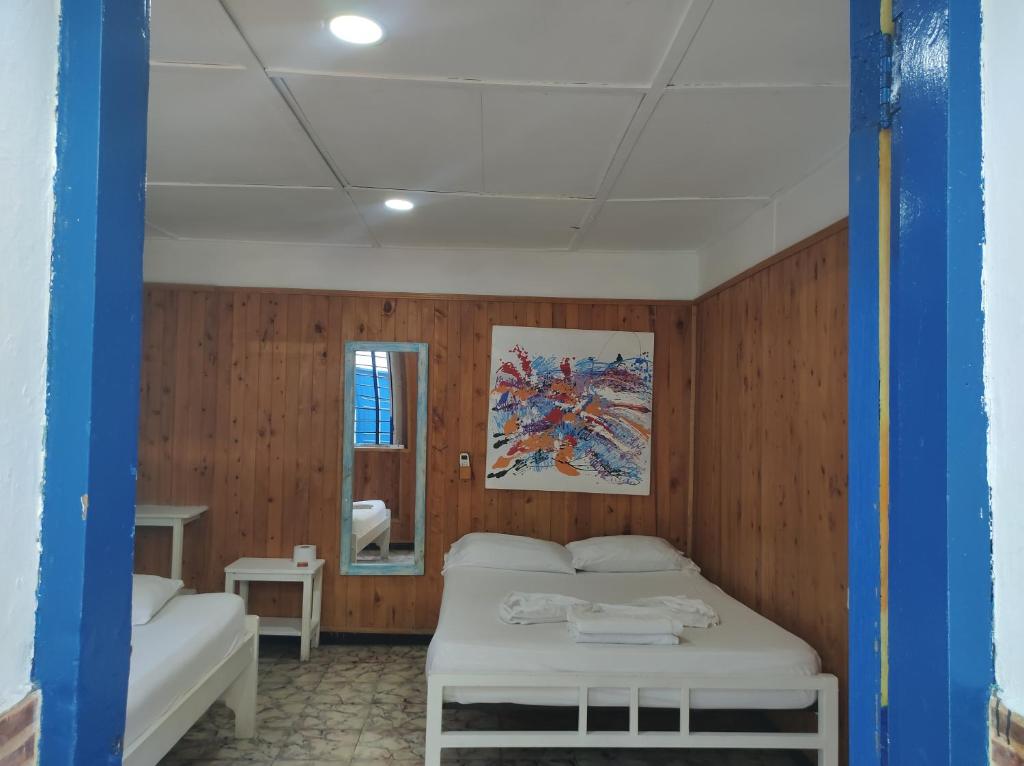 a small room with a bed and a mirror at Casa Hostal Luna Llena in Cartagena de Indias
