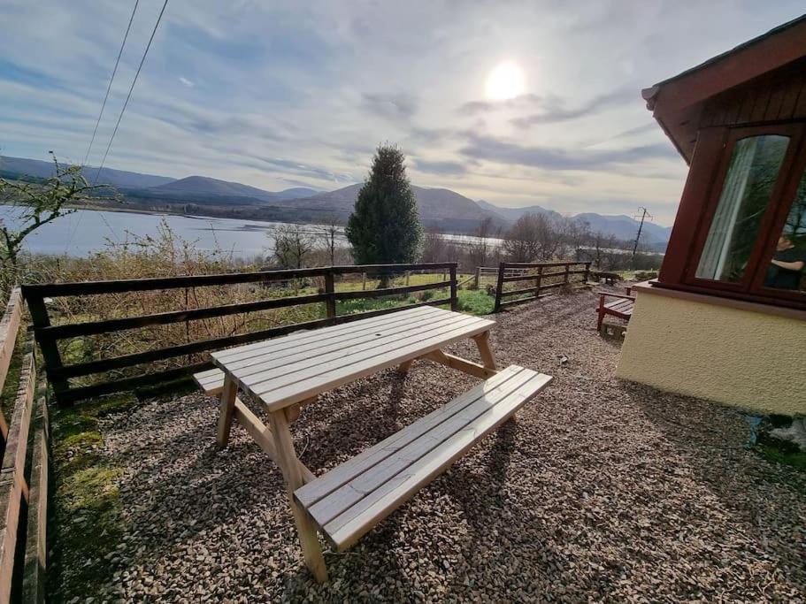 a wooden bench sitting in front of a fence at Altdarroch Farm House in Kinlocheil