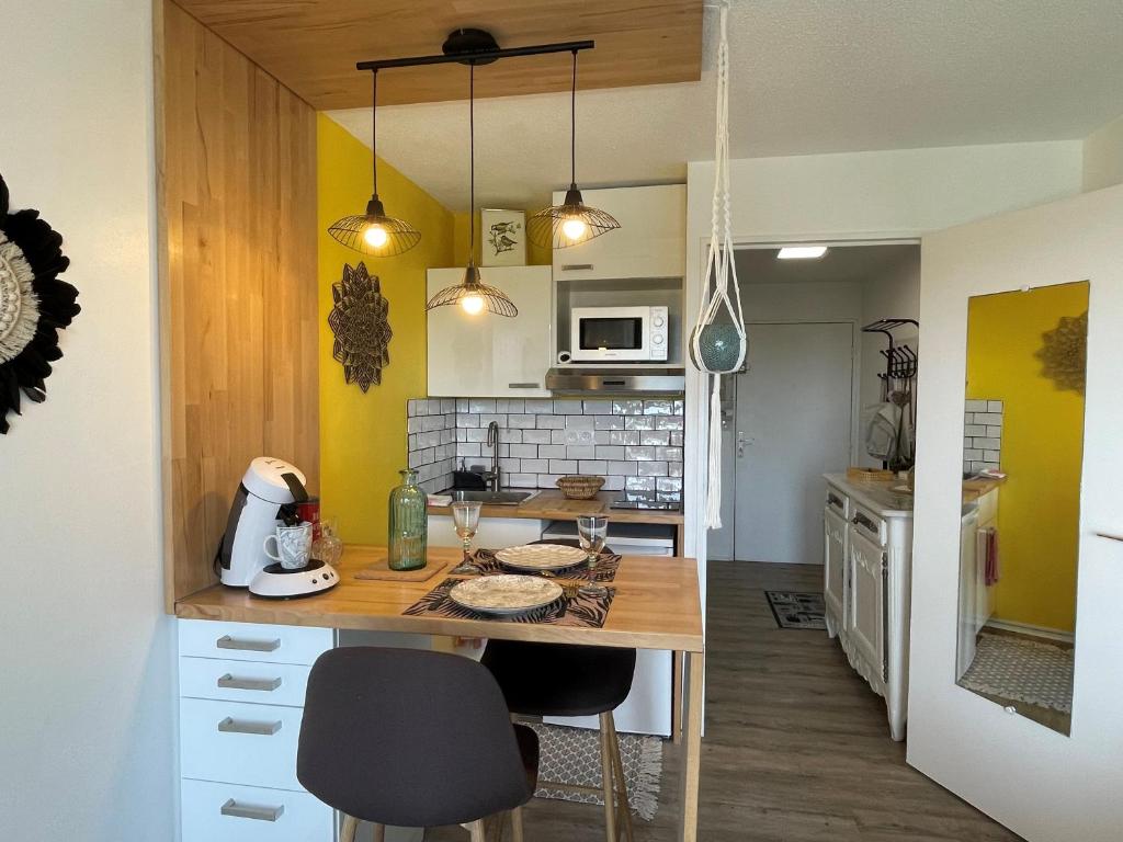 een keuken met een tafel en stoelen in een kamer bij Studio avec balcon à 50 m de la corniche vendéenne in Saint-Hilaire-de-Riez