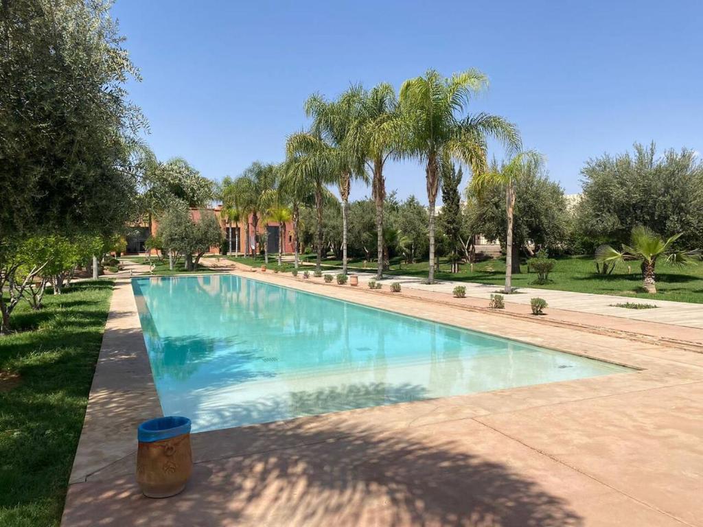 uma piscina num quintal com palmeiras em Appartement Privé 1 Chambre Vizir Center Marrakech em Marrakech