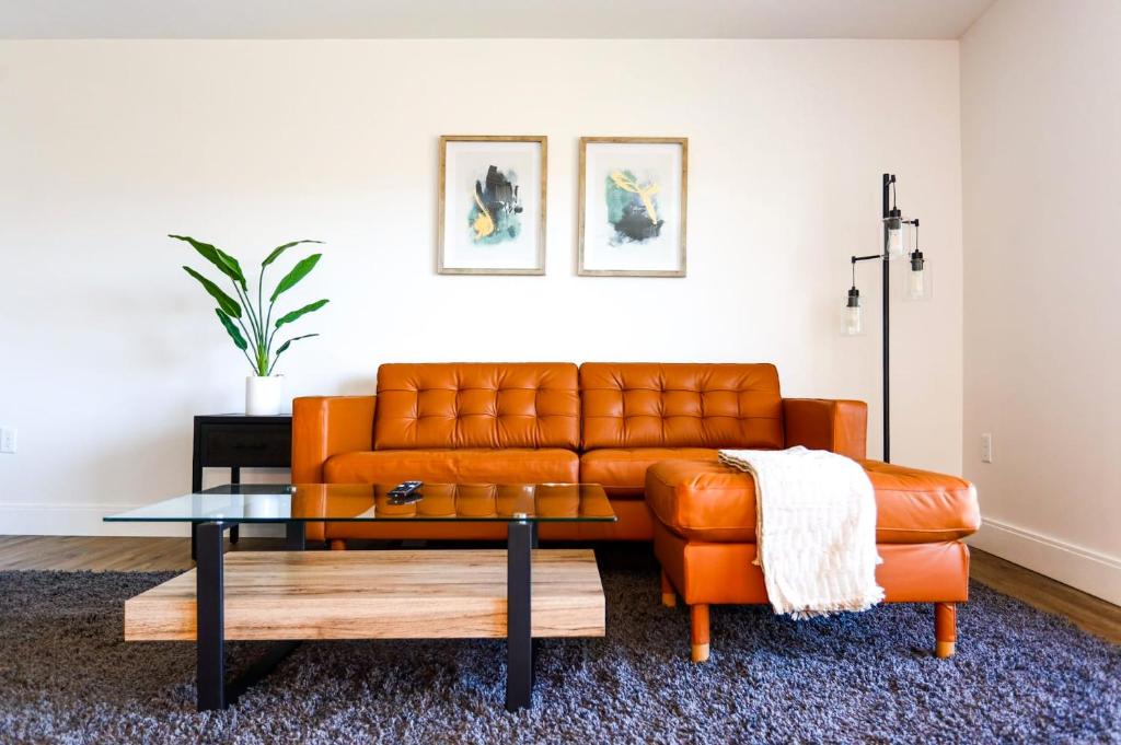 an orange leather couch in a living room with a coffee table at 1BR Luxury Apartment Peabody - Unit #606 in Peabody