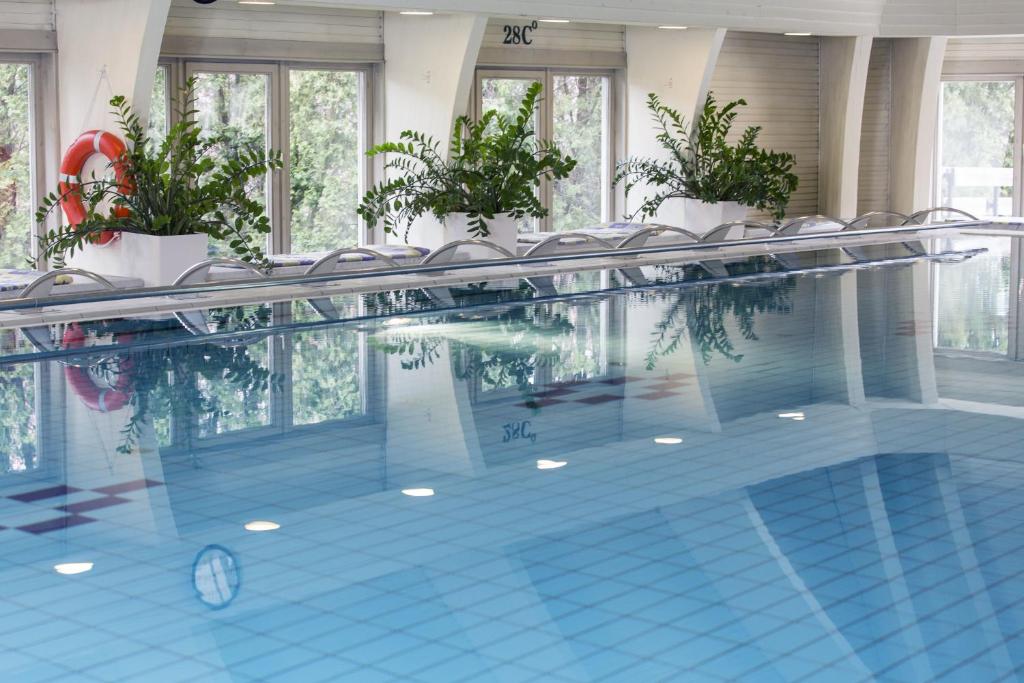 a large swimming pool with chairs in a building at Ensana Thermal Hévíz in Hévíz