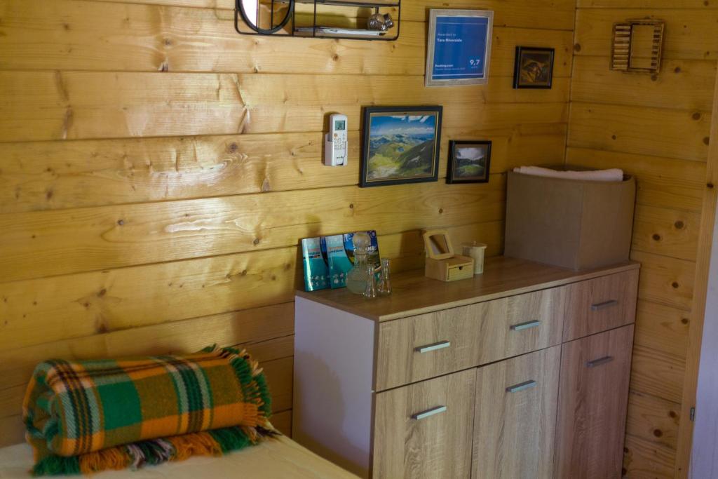 um quarto com uma parede de madeira e um frigorífico em Tara Riverside em Mojkovac