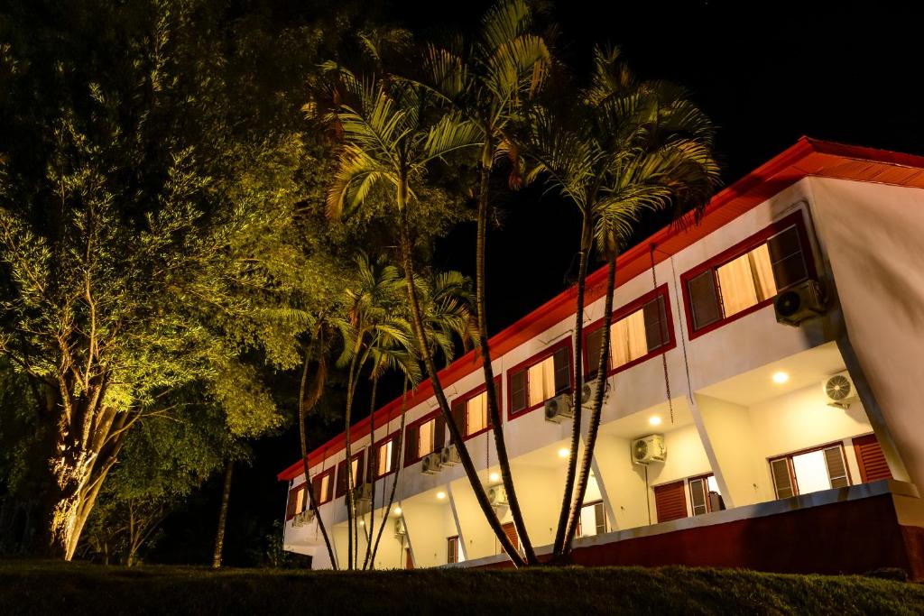 a building with palm trees in front of it at Hotel Fazenda Aguas de Lindoia in Águas de Lindoia