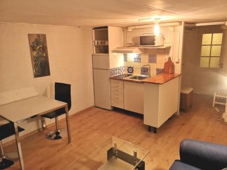 a living room with a kitchen with a table and a counter at Trevligt källare lägenhet in Jönköping