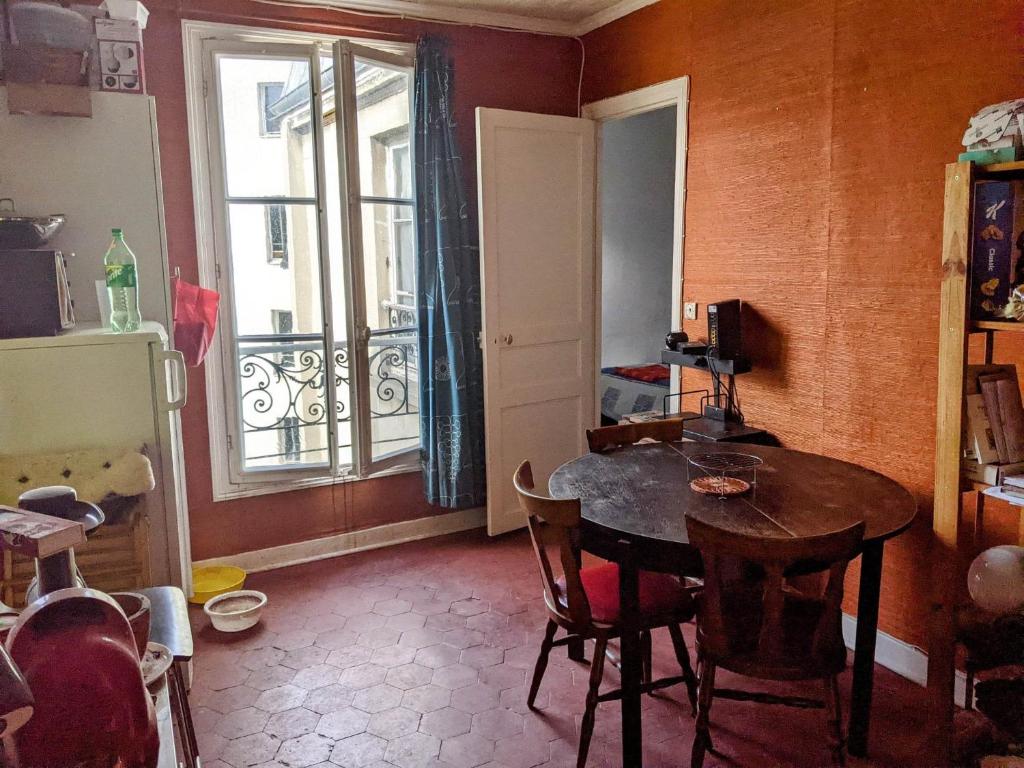 une salle à manger avec une table et une fenêtre dans l'établissement Appartement ancien, à Paris