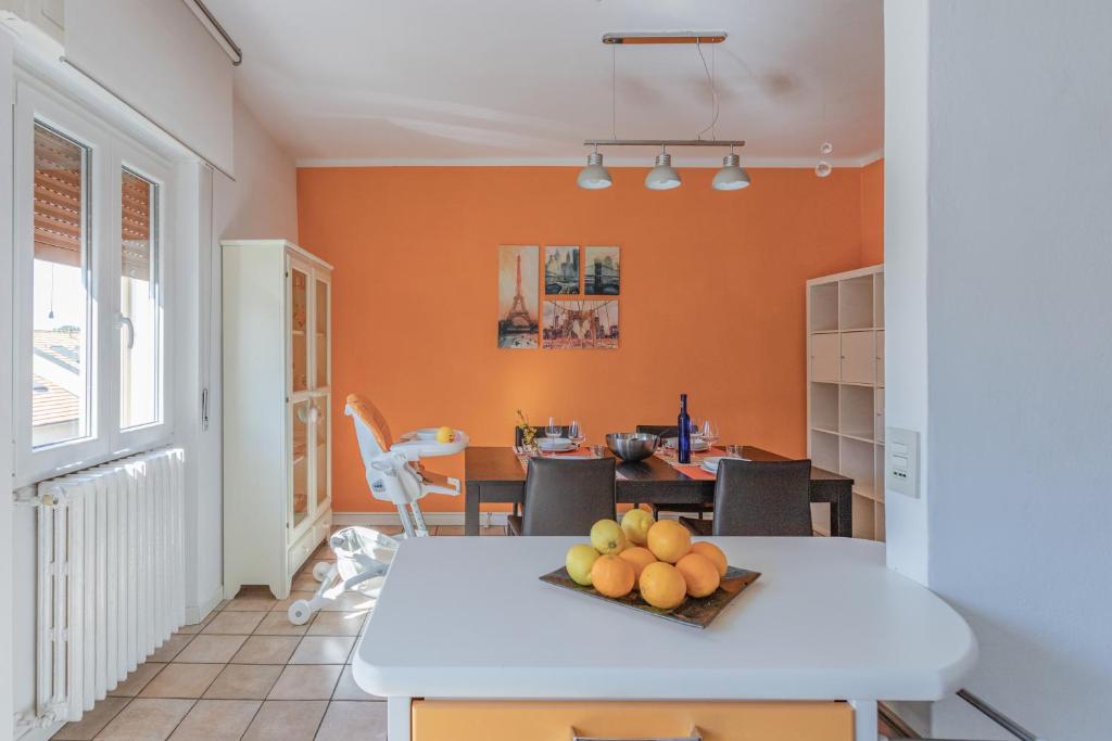 een keuken met oranje muren en een tafel met fruit erop bij Casa Eleonora - Pavia - By HOST4U in Pavia