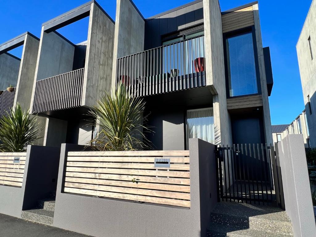 a house with a wooden fence in front of it at Worcester Terrace One - Christchurch Holiday Homes in Christchurch