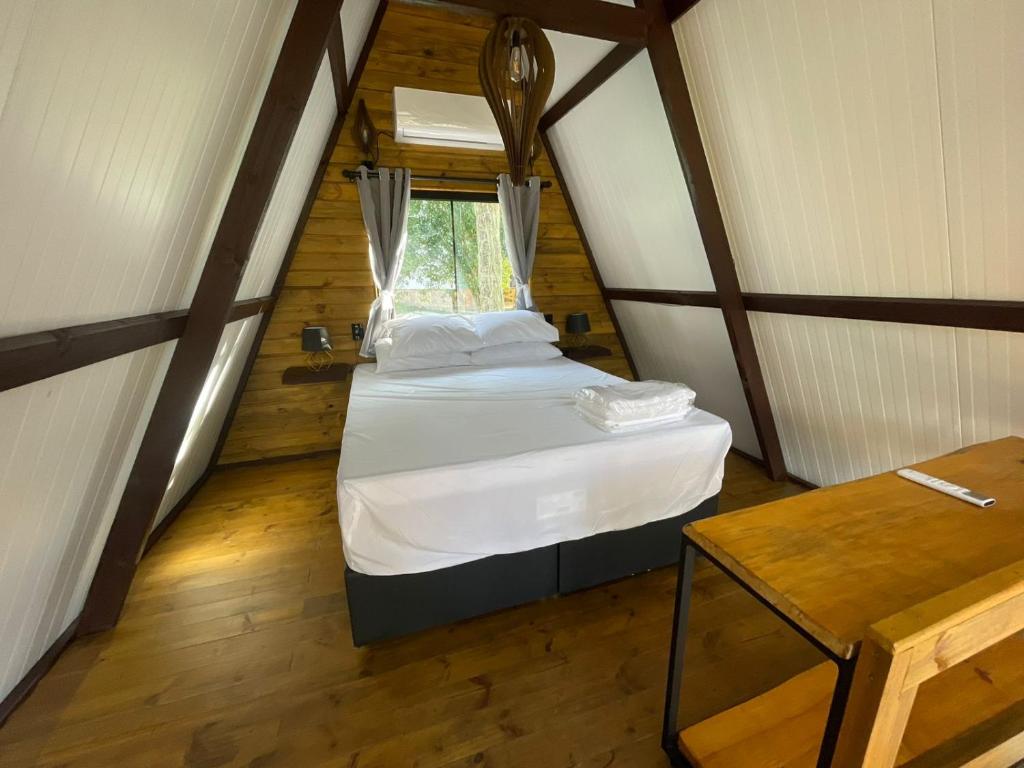 a small bedroom with a bed in a attic at Pousada Recanto da Neve in Urubici