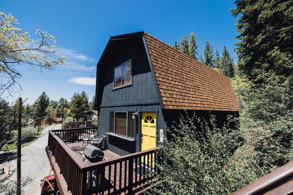 a black house with a yellow door on a deck at Amazing Cabin - Close To Ski Resort and Village in Big Bear Lake