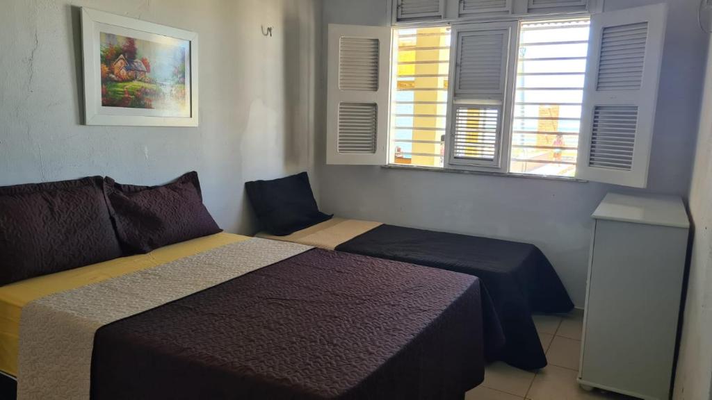 1 dormitorio con 2 camas y 2 ventanas en Pé na Areia, en Itapipoca