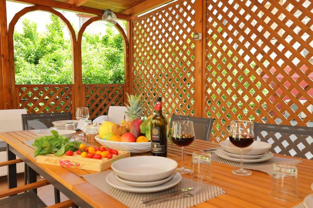 a wooden table with plates and glasses of wine at Franco's house Sorrento in Sorrento