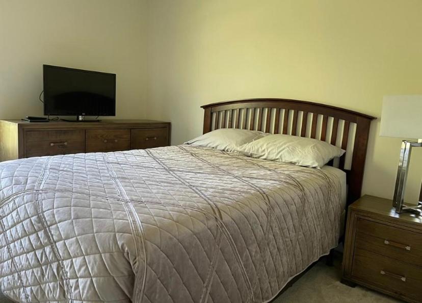 Schlafzimmer mit einem Bett und einem Flachbild-TV in der Unterkunft Private Bed and Bath in Charlotte in Charlotte