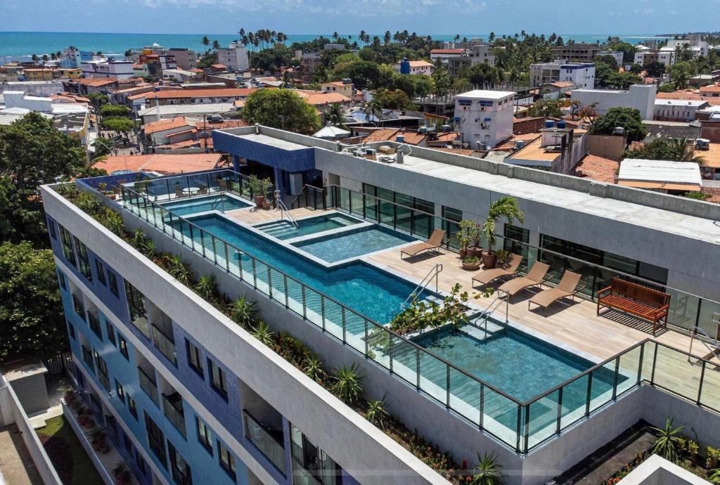 an aerial view of a building with a swimming pool at Flat Premium No Centro in Porto De Galinhas