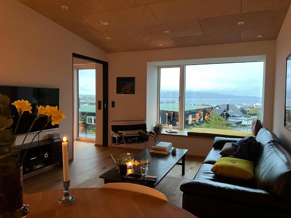 uma sala de estar com um sofá e uma mesa em Atlantic Jewel em Tórshavn