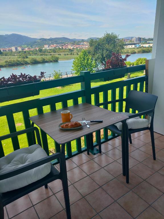une table et des chaises sur un balcon avec vue sur une rivière dans l'établissement Hendaya vistas increíbles, à Hendaye