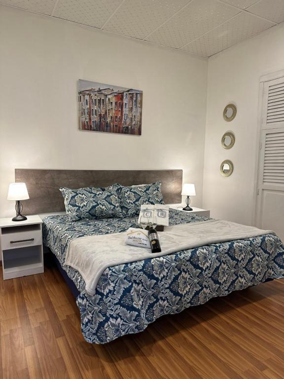 1 dormitorio con 1 cama con manta azul y blanca en Casa Balthazar Hostel, en Quito