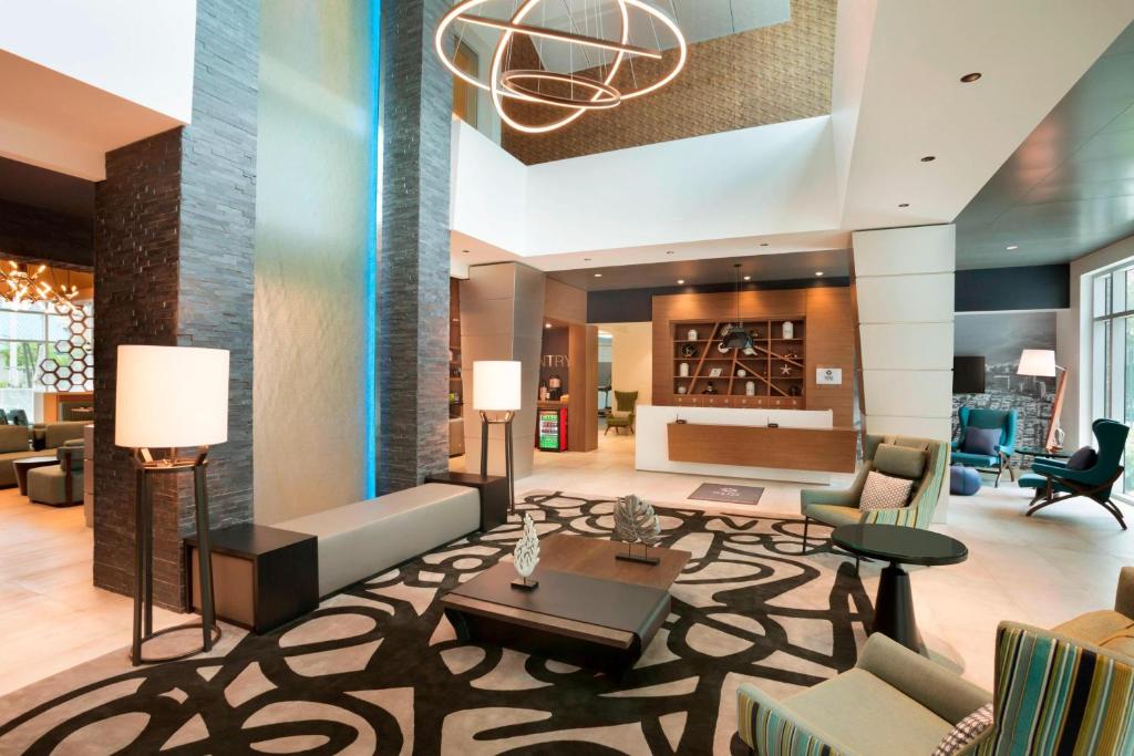 - un hall d'un hôtel avec des canapés et des chaises dans l'établissement Four Points by Sheraton Miami Airport, à Miami