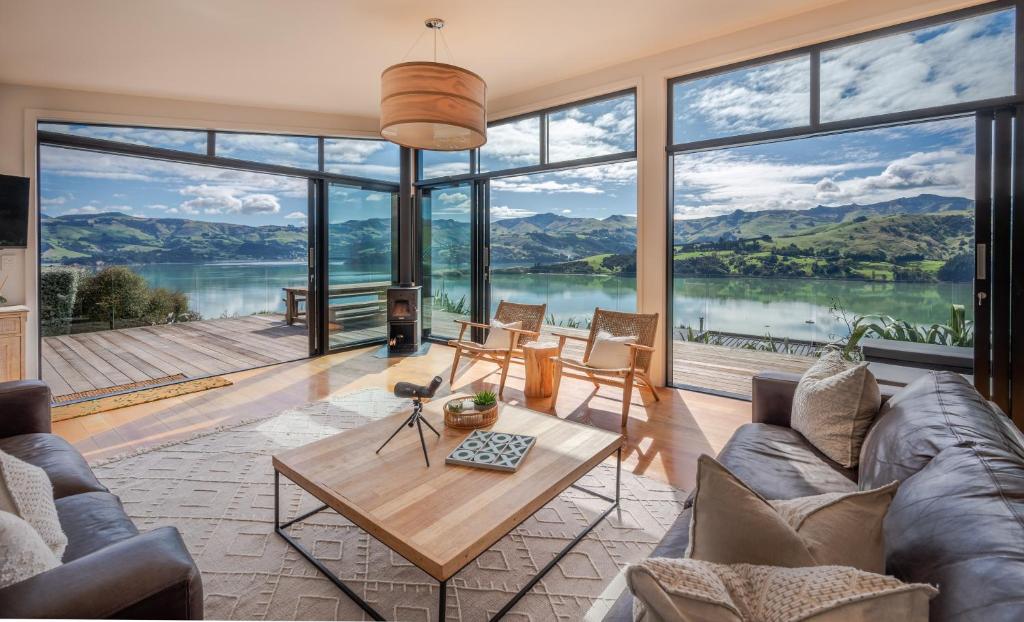a living room with a view of a lake and mountains at Million Dollar View - Takamatua Holiday Home in Akaroa