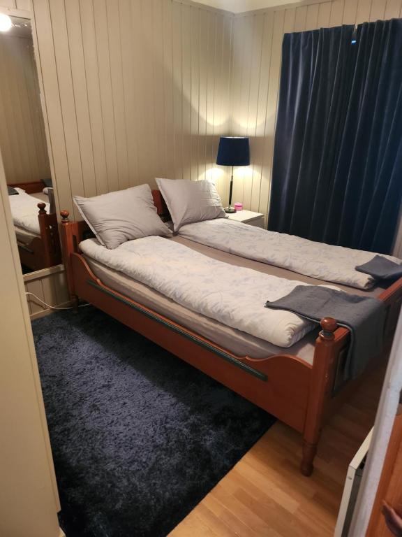 1 dormitorio con 1 cama con cortina azul en Apartment By The Lakeside, en Tromsø