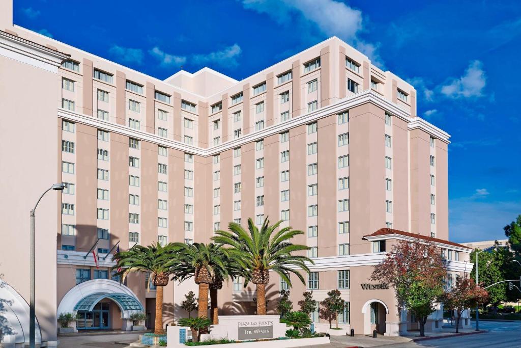 um grande edifício rosa com palmeiras em frente em The Westin Pasadena em Pasadena