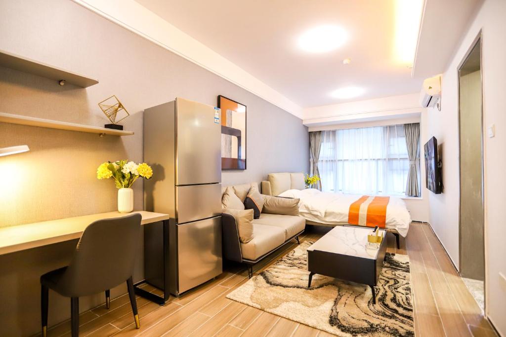a small living room with a bed and a desk at Shenzhen B T Miele Executive Apartment - Baoan International Airport Bihaiwan Subway Station in Shenzhen