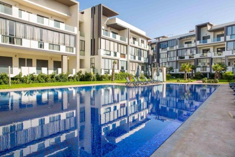 - une piscine en face de certains immeubles dans l'établissement Appartement spacieux avec piscine à Dar Bouazza - Casablanca, à Casablanca