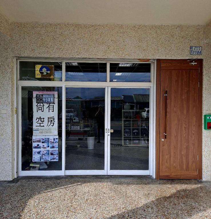 a glass door of a store with a sign in it at Jia Mei Fa Homestay in Taitung City