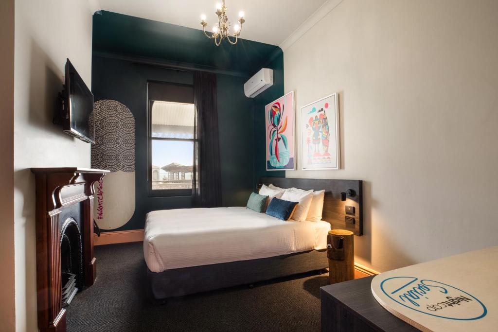 a small bedroom with a bed and a window at Ramsgate Hotel by Nightcap Social in Adelaide