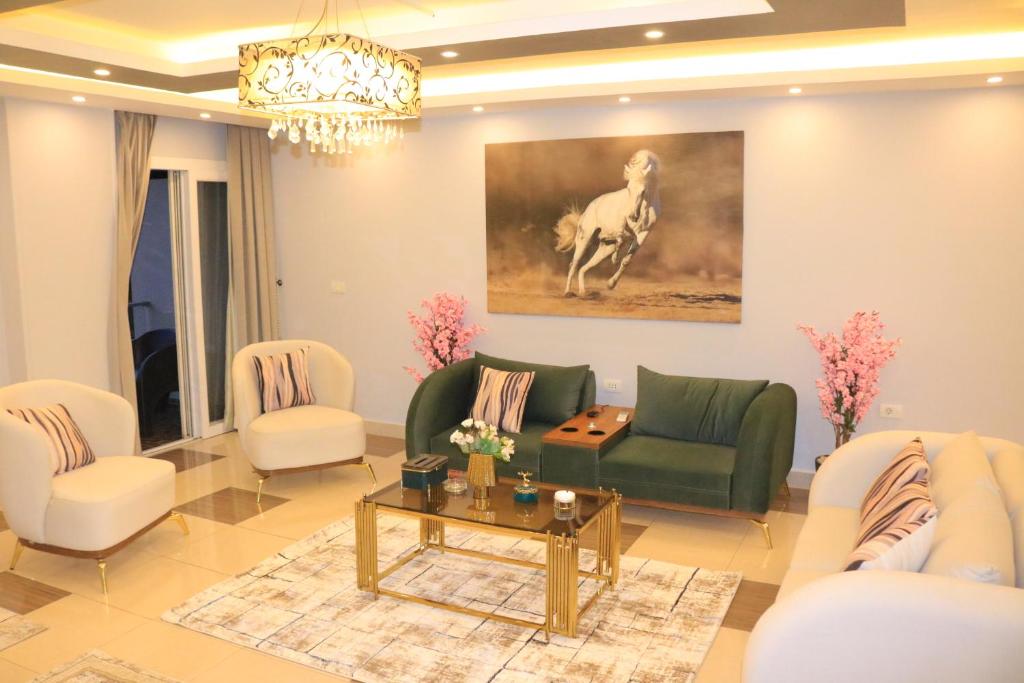 كومبوند زايد ديونز في Sheikh Zayed: غرفة معيشة مع أريكة وكراسي خضراء