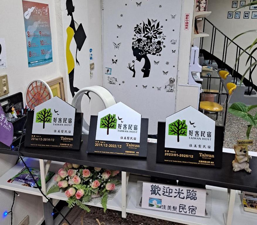 a shelf with signs on it with flowers and birds at Jia Mei Fa Homestay in Taitung City