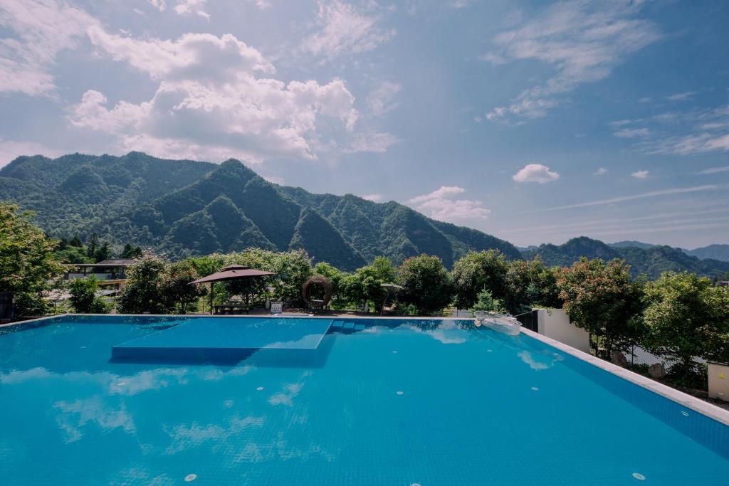 张家界Avatar Mountain Resort的以群山为背景的游泳池