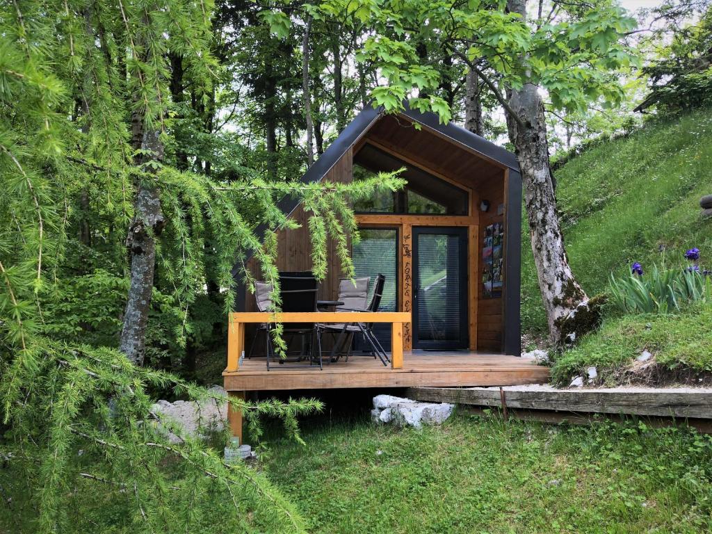 Une petite maison dans les bois avec une table. dans l'établissement Mountain lodge Forte Emilia, à Kobarid