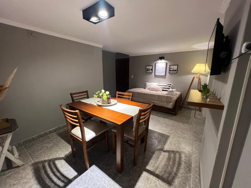 a living room with a dining room table and a bed at Departamento frente a plaza libertad 1hab in Santiago del Estero