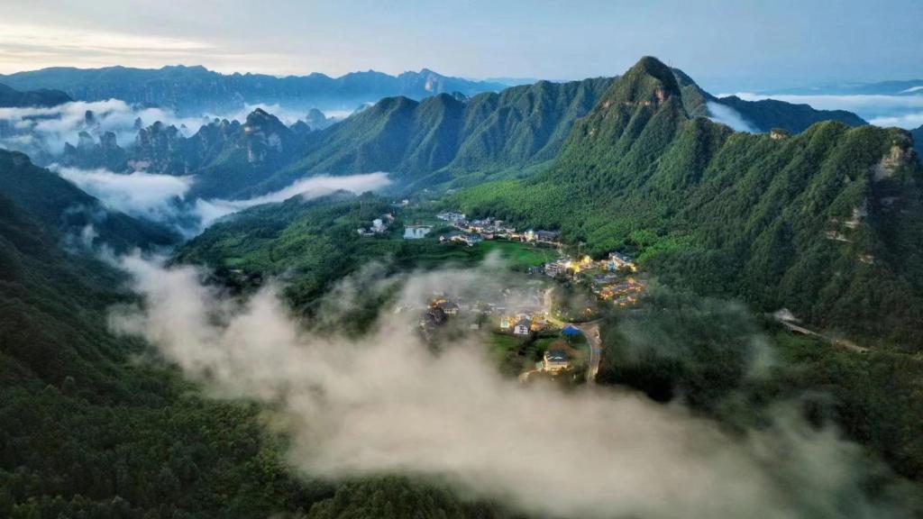 an aerial view of a mountain valley with clouds at Avatar Mountain Resort in Zhangjiajie