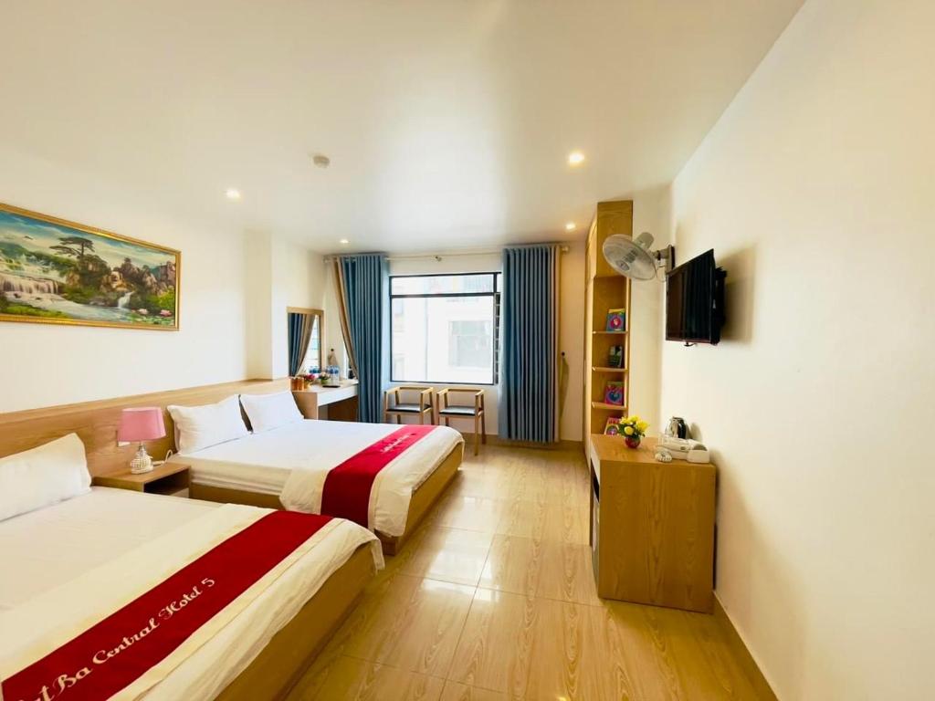 ein Hotelzimmer mit 2 Betten und einem TV in der Unterkunft Grand Budapest Hotel in Cát Bà