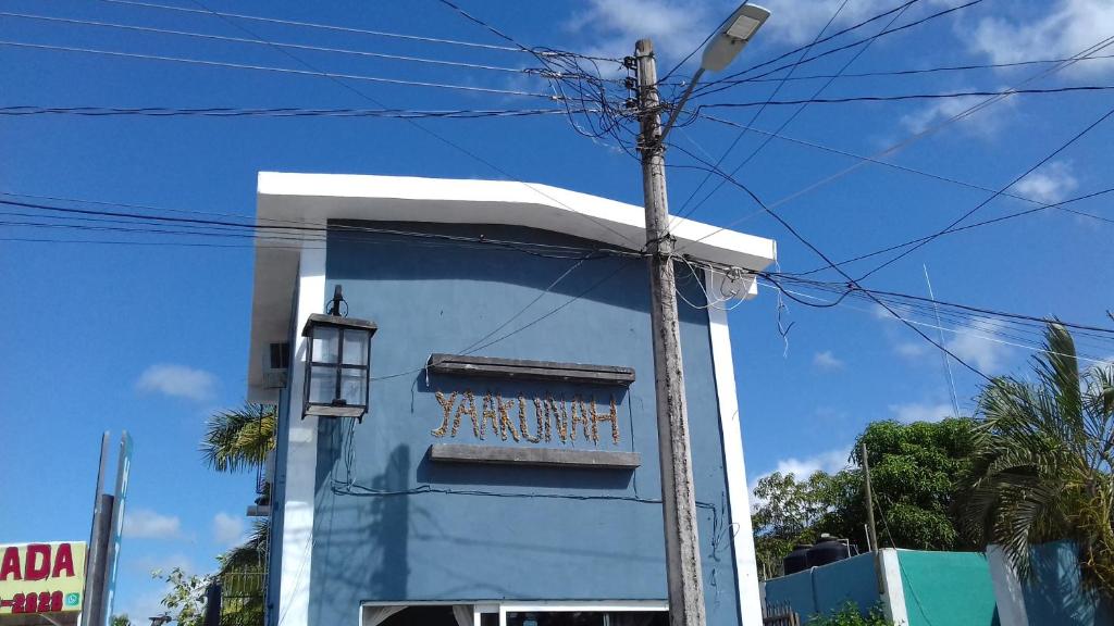 un edificio azul con un cartel en el costado en casa YAAKUNAH, en Escárcega