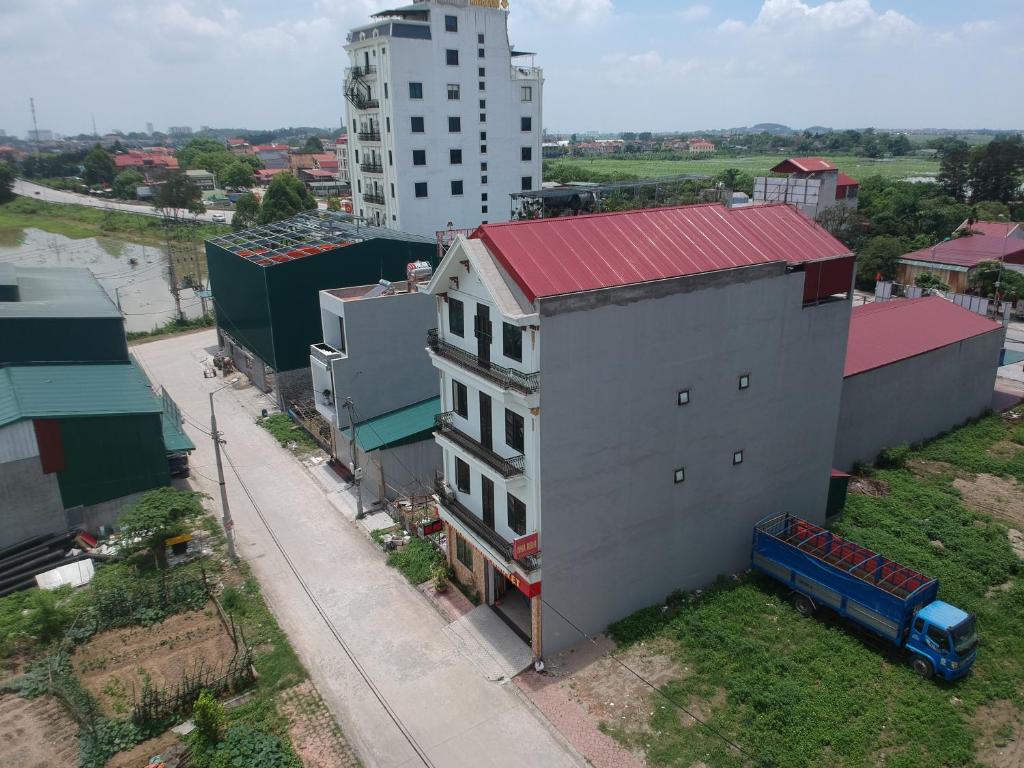 a white building with a red roof next to a street at Hotel Như Nguyệt in Việt Yên