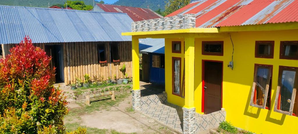 a model of a yellow house with a red roof at Ruteng Hostel in Ruteng