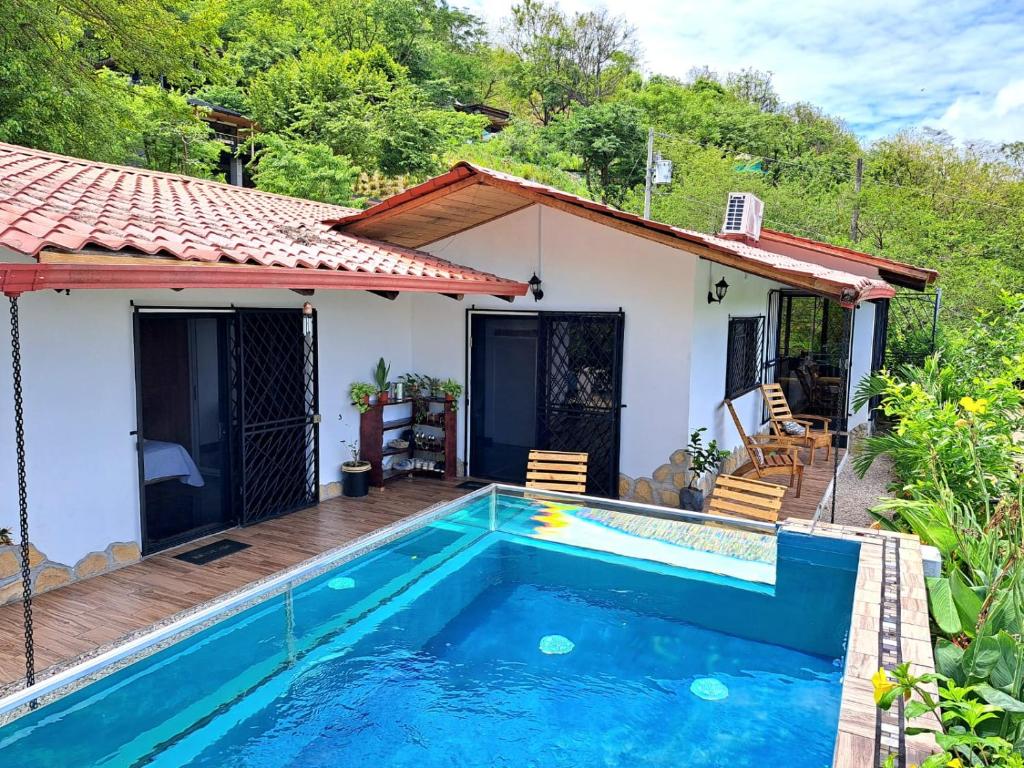 a villa with a swimming pool in front of a house at Casa Namaste del Pacifico - Luxury Villa in Santa Teresa Beach