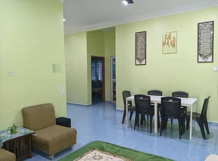 a dining room with a table and chairs at Homestay sunnah bougainvillea resident Islam 