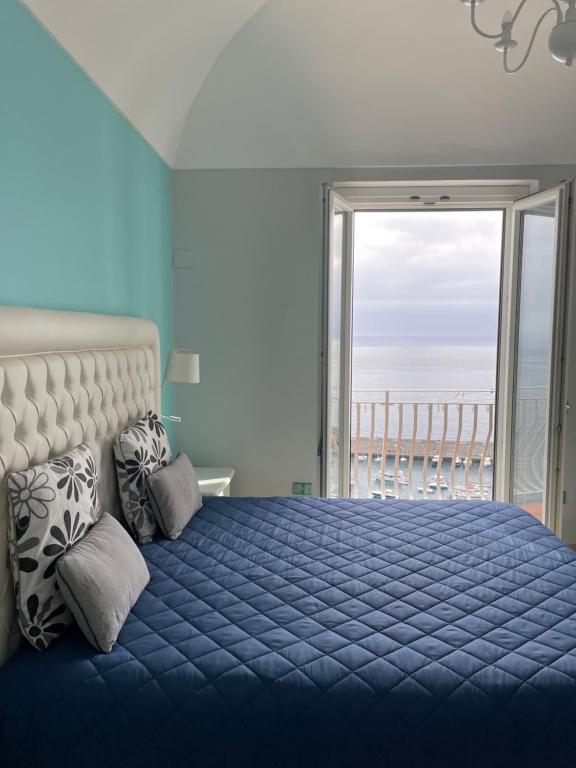 1 dormitorio con cama azul y vistas al océano en Apartments Amalfi Design Sea View accessible by 250 steps en Amalfi