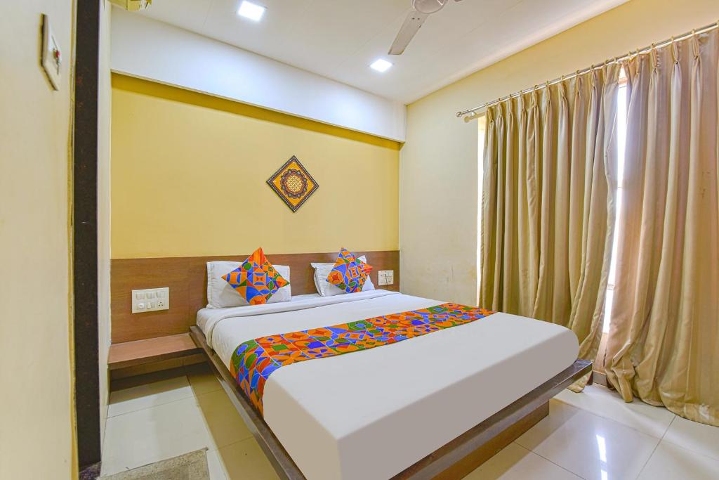 a bedroom with a large bed in a room at FabHotel RB Residency in Surat