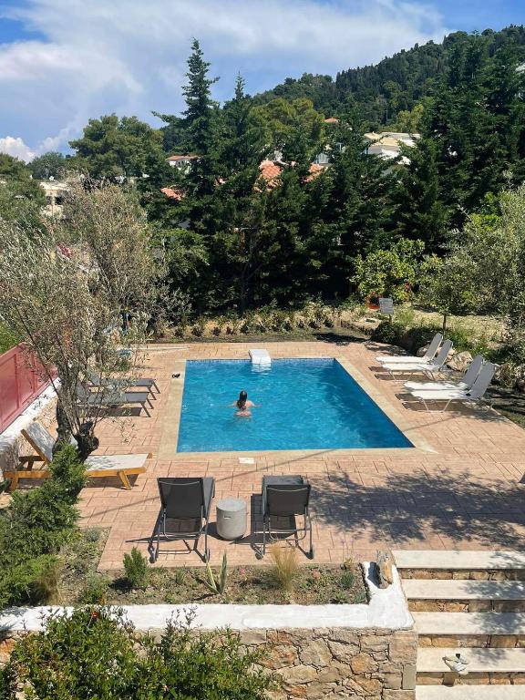 a person is swimming in a swimming pool at Nissi Collection Rooms in Argassi