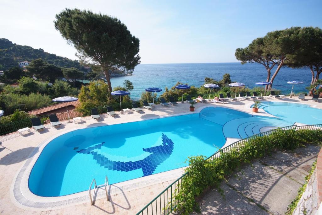 a swimming pool with the ocean in the background at Hotel da Giacomino in SantʼAndrea