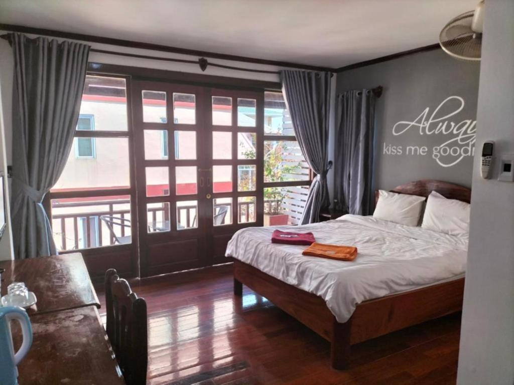 a bedroom with a bed with a sign on the wall at DaViKa Hotel in Vientiane