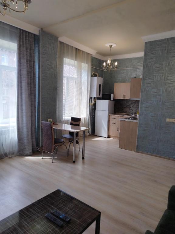 a living room with a table and a kitchen at Отличная квартира в центре Ванадзора in Vanadzor